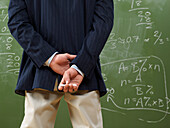 Teacher Looking at Math Problems on Blackboard