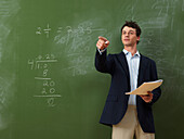 Teacher Standing in Front of Blackboard