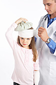 Arzt wickelt Verband um den Kopf eines Mädchens