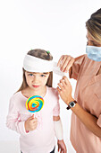 Nurse Wrapping Bandage Around Girl's Head