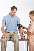 Krankenschwester misst den Blutdruck eines Mannes