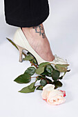 Woman With Tattoo Stepping on a Rose