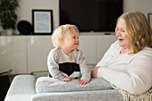 Mother and baby with down syndrome sitting in sofa