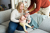 Parents and baby with down syndrome on sofa