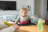 Toddler with down syndrome sitting at table