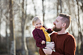 Father holding smiling baby with down syndrome