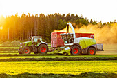 Tractor and combine harvester working in field