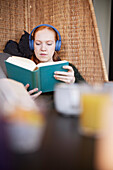 Junge Frau studiert, liest ein Buch im Cafe