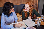Lächelnde junge Frauen beim gemeinsamen Lernen