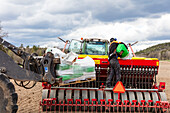 Farm machine working in plowed field