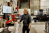 Junge Industriearbeiterin bei der Arbeit in der Fabrik