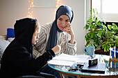 Mother wearing hijab helping son with ADD or ADHD doing homework