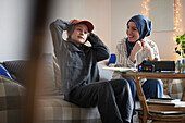 Hijab tragende Mutter hilft müdem Sohn mit ADS oder ADHS bei den Hausaufgaben
