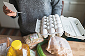 Frau prüft Kassenzettel im Supermarkt während der Inflation mit Preisanstieg bei Lebensmitteln und Konsumgütern