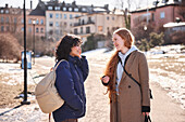Female friends talking together in city surroundings