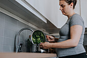 Schwangere Frau in der Küche bei der Essenszubereitung