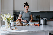 Frau in Küche bei der Essenszubereitung
