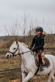 View of girl horseback riding