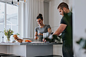 Couple in kitchen preparing food together