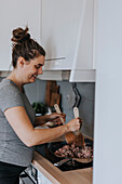 Pregnant woman in kitchen preparing food