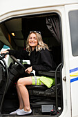 Portrait einer lächelnden jungen Frau beim Fahren eines Fernlastwagens