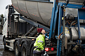 Young female construction worker operating machinery