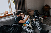 Father hugging disabled child on sofa