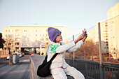 Blick auf einen sitzenden Jungen, der ein Selfie macht