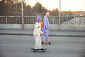Young woman and boy skateboarding together