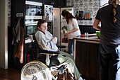 Eltern mit behinderter Tochter im Rollstuhl bereiten in der Küche Essen zu