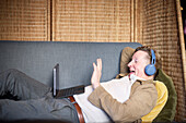Älterer Mann mit Kopfhörern bei einem Videogespräch auf einem Tablet