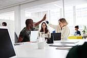 Group of business people high-five during business meeting in office