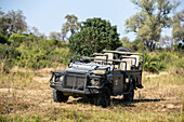 A safari vehicle, parked in the African wilderness.