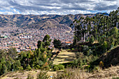 Cusco, Blick von oben auf die Dächer der Stadt Cusco, Terrassen an den Hängen und Waldgebiete.