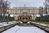 Peterhof Baroque summer palace, the facade o fthe buildings and the Grand Cascade in the gardens, a water pool and golden fountains, in winter. 