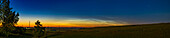Dies ist ein Teleobjektiv-Panorama einer niedrigen und späten Anzeige von nachtleuchtenden Wolken im Norden am 7. August 2022. Dies war die letzte NLC, die ich von meinem Breitengrad 51° N aus gesehen habe. Die Aufnahme entstand von zu Hause in Süd-Alberta aus in einer Nacht, in der auch eine Aurora-Show der Stufe Kp5 zu sehen war, die STEVE einschloss.