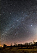 Ein Horizont-zu-Zenit-Panorama der Wintersternbilder an einem Märzabend, wenn sie im Südwesten untergehen. Orion befindet sich unten in der Mitte, sein Gürtel zeigt nach unten zum Canis Major und nach oben zum Taurus. Zwillinge und Auriga befinden sich oben, in diesem Fall in der Nähe des Zenits über dem Himmel. Die hellen Sternhaufen M44, der Bienenstock, (links) und M45, die Plejaden, (rechts) flankieren die Milchstraße. M45 ist in das Zodiakallicht eingebettet. Die Sternhaufen M35 in Zwillinge und M41 in Canis Major sind ebenfalls als diffuse Flecken sichtbar, ebenso wie mehrere andere Ster