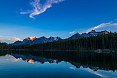 Sonnenuntergang am Herbert Lake, Banff National Park, Alberta, mit dem letzten Sonnenlicht, das die Gipfel rund um Lake Louise an der Kontinentalscheide in einem Alpenglühen erstrahlen lässt. Der Hauptgipfel links ist Mount Temple.