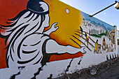 A painted wall mural depicting indigenous culture on the street in Villa San Agustin in San Juan Province, Argentina.