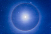 Ein Eiskristallhalo um den ersten Viertelmond hoch am nördlichen Winterhimmel, am 27. Januar 2015, aufgenommen von der Nähe von Pinos Altos, New Mexico. Die Plejaden befinden sich oberhalb und links des Mondes, die Hyaden und Aldebaran links davon. Der grüne Komet Lovejoy (C/2014 Q2) befindet sich im Mondhalo oben.