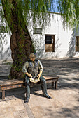 Statue of Domingo Sarmiento sitting on a bench in front of the Birthplace Museum of Domingo F. Sarmiento, San Juan, Argentina.