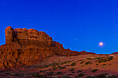 The total lunar eclipse of April 4, 2015 at dawn over the Tear Drop Arch Mesa at Monument Valley, Utah. This is a blend of three exposures: a 44-second shot at f/3.5 and ISO 800 for the sky (with the camera on the Star Adventurer tracker to track the sky for the sharp stars) and an identical exposure with the tracker motor off (for the sharp foreground), plus a short 1-second exposure for the eclipsed Moon blended with its over exposed image. All frames with the 16-35mm lens at 26mm and with the Canon 60Da. Frames shot at ~6:07 am. MDT, about 4 minutes after totality as the sky and landscape w