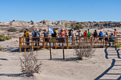 Touristen auf der Promenade in der kargen Landschaft im Ischigualasto Provincial Park, Provinz San Juan, Argentinien.