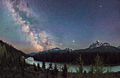 Die Milchstraße, in der Mythologie oft als Fluss am Himmel beschrieben, leuchtet in einer sehr klaren Nacht Anfang Juni über dem Bow River im Banff National Park.