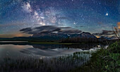 The Milky Way over Maskinonge Lake at Waterton Lakes National Park, Alberta, Canada, on June 17/18, 2018. This was an unusually calm night, allowing the reflections of the stars in the lake waters. Jupiter is in Libra at far right. Saturn is Sagittarius in the Milky Way at left of centre. Scorpius is in between. The sky is deep blue from solstice twilight.