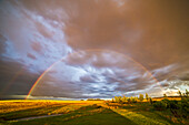 A rainbow near sunset from hom in Alberta, May 31, 2014, taken with the 14mm Rokinon ultra wide angle lens. A fainter outer bow is also visible.