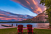 Die ikonischen Red Chairs von Parks Canada im Licht des Sonnenuntergangs am Middle Waterton Lake im Waterton Lakes National Park, am 17. Juni 2017. Vimy Peak ist rechts zu sehen.