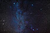 A composite of several exposures to stack images of five Geminid meteors into a wide view of the winter sky with Comet Wirtanen at upper right in Taurus, taken on December 12, 2018. The meteors are shooting away from the radiant point in Gemini near the bluish-white star Castor at left. The Milky Way runs vertically through the frame from Auriga at top to past Orion at bottom.