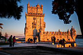 People enjoy a beautiful sunset from Belem Tower or Tower of St Vincent on the bank of the Tagus River, Lisbon, Portugal