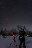 A self-portrait of me observing the total eclipse of the Moon on November 8, 2022, on a very cold (-25° C) morning at 4 am. Above the red Moon are the stars of Taurus including the Hyades and Pleiades star clusters.